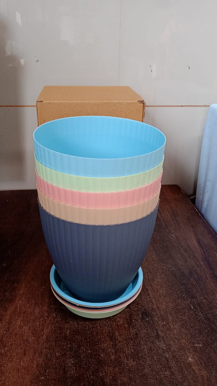 An empty black plastic flower pot with its tray, ready for planting and gardening use.