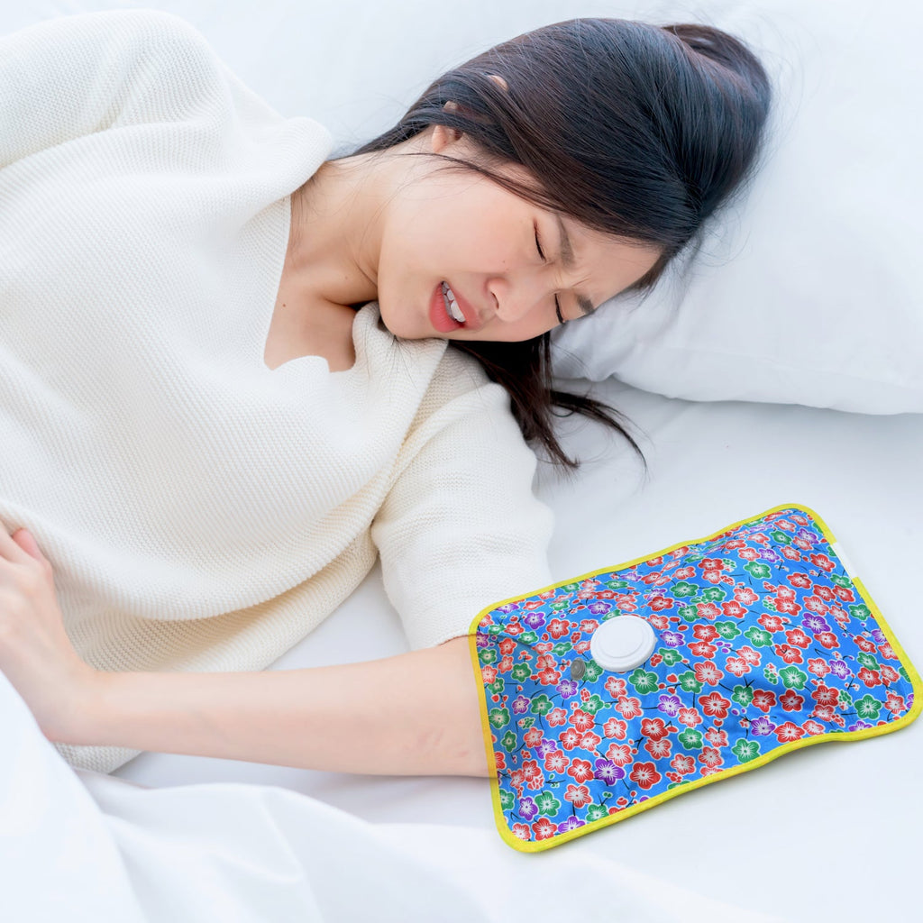 Person using the electric heating pad on their lower back for muscle pain relief.