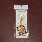 Om Trishul symbol keychain resting on surface, showcasing design and metal material