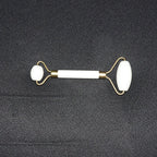 Dual-ended face massage roller displayed on a minimalist white background.