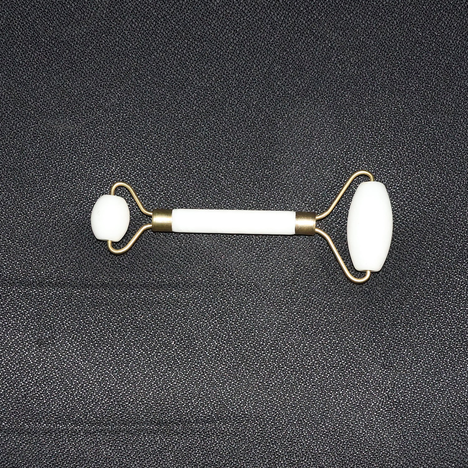 Dual-ended face massage roller displayed on a minimalist white background.