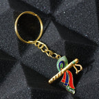 Close-up of Krishna metal keychain featuring flute and peacock feather motif