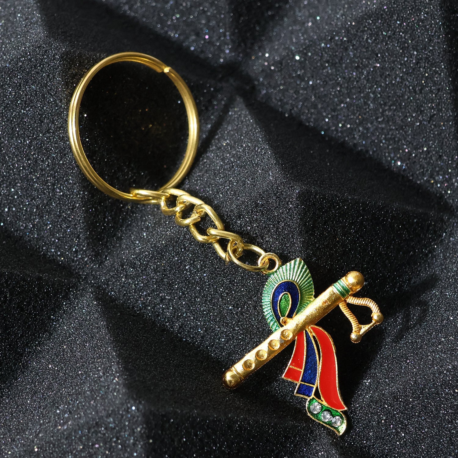 Close-up of Krishna metal keychain featuring flute and peacock feather motif