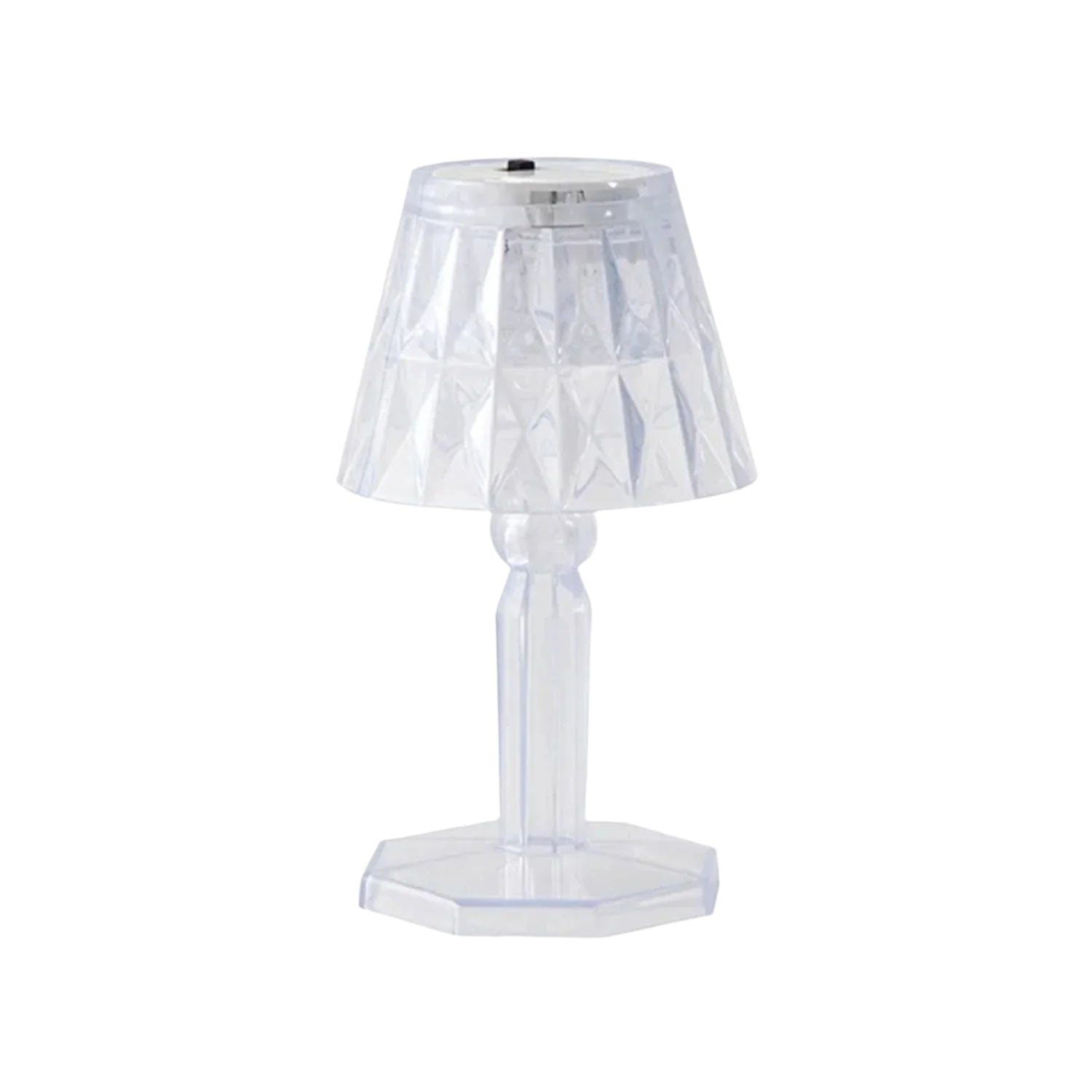 A compact crystal table lamp reflecting light onto a wall.