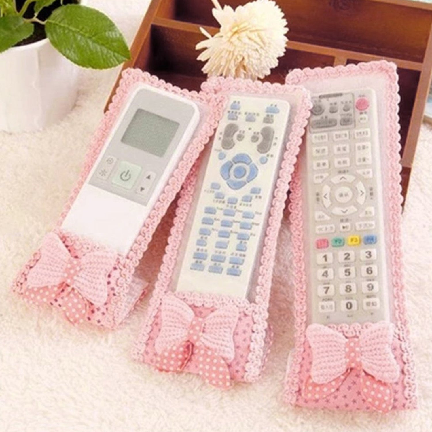 A decorative remote control cover with a bow knot, providing dust protection for TV remotes.