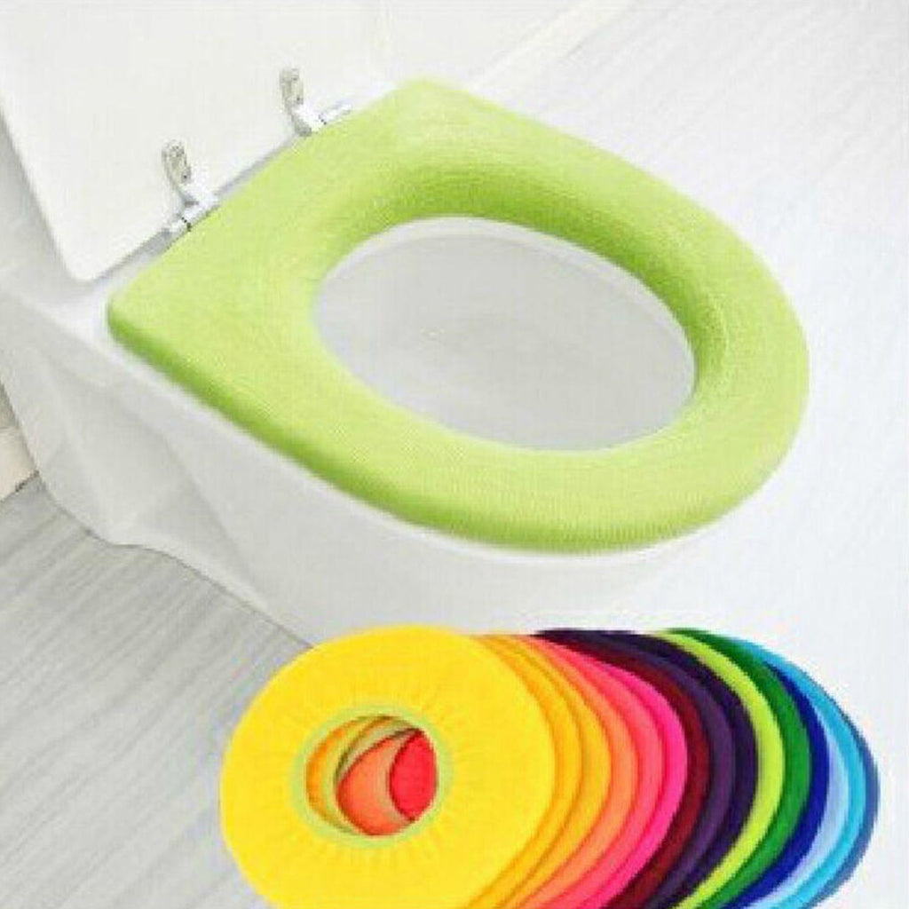A person's hand touching the warm, comfortable surface of the toilet seat cover.