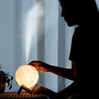 Person refilling the water tank of the 3D Moon Lamp Diffuser for aromatherapy
