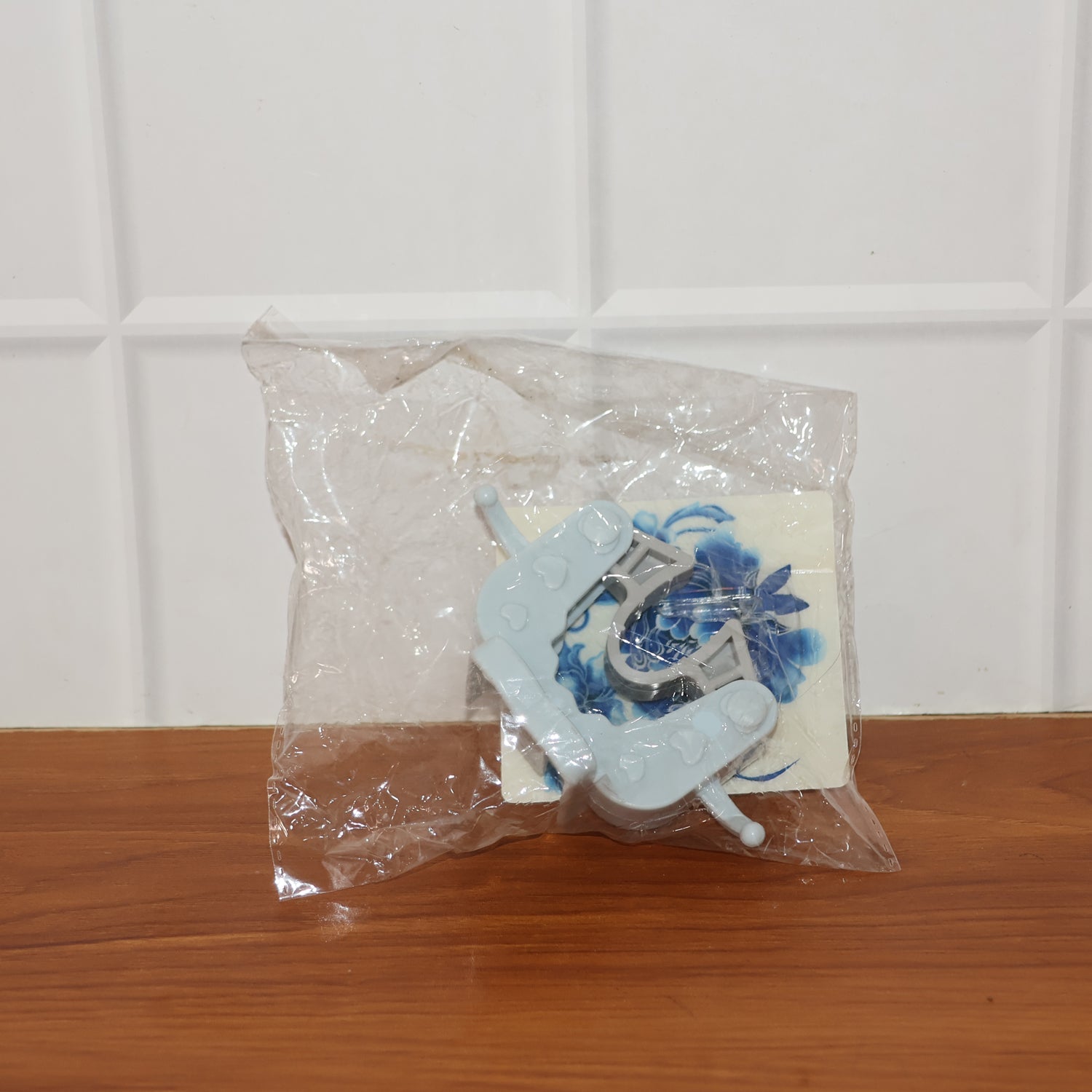 Wall mounted mop and broom holder clip installed on tiled wall for storage
