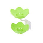 Flower-shaped self-draining soap dish mounted on a bathroom wall with a soap bar.