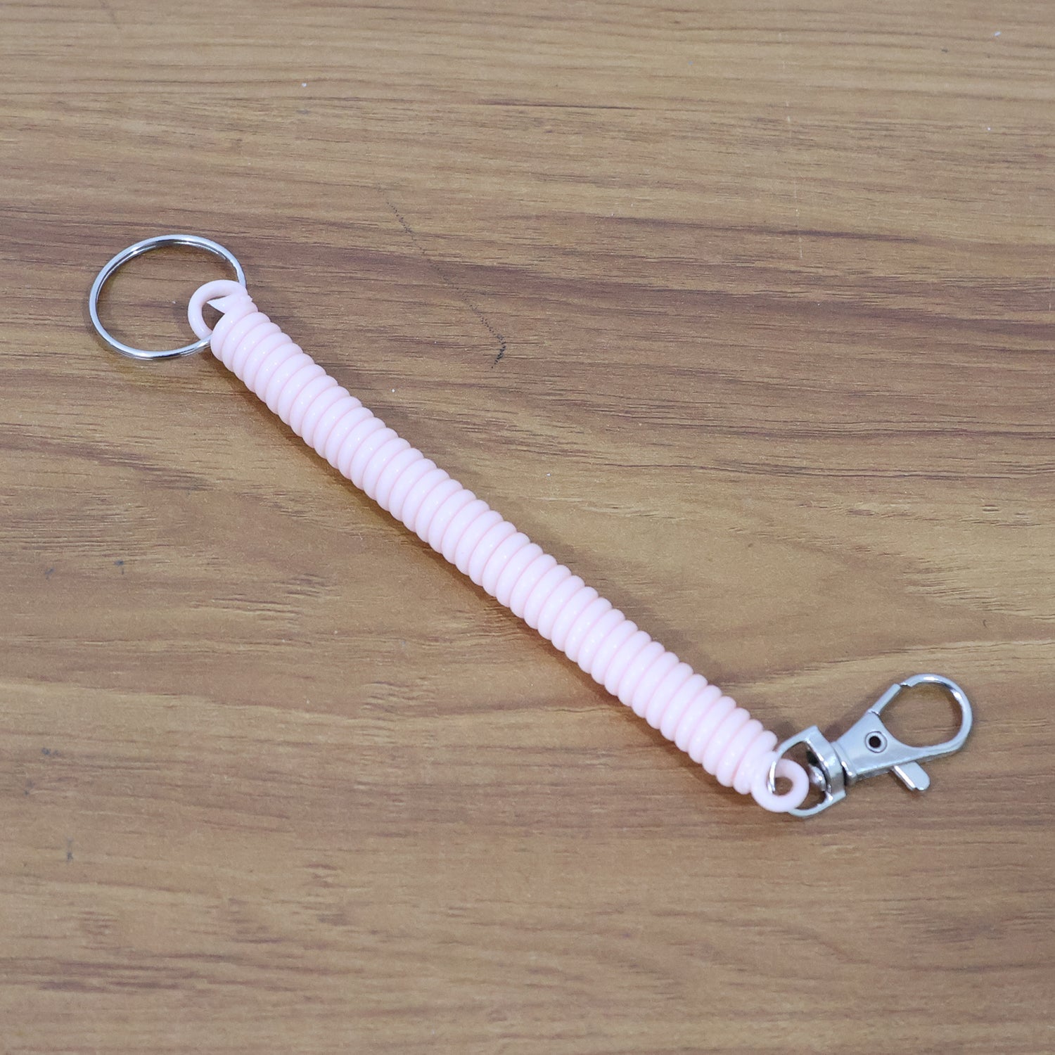 Side angle of elastic spiral coil keychain bracelet highlighting coil flexibility