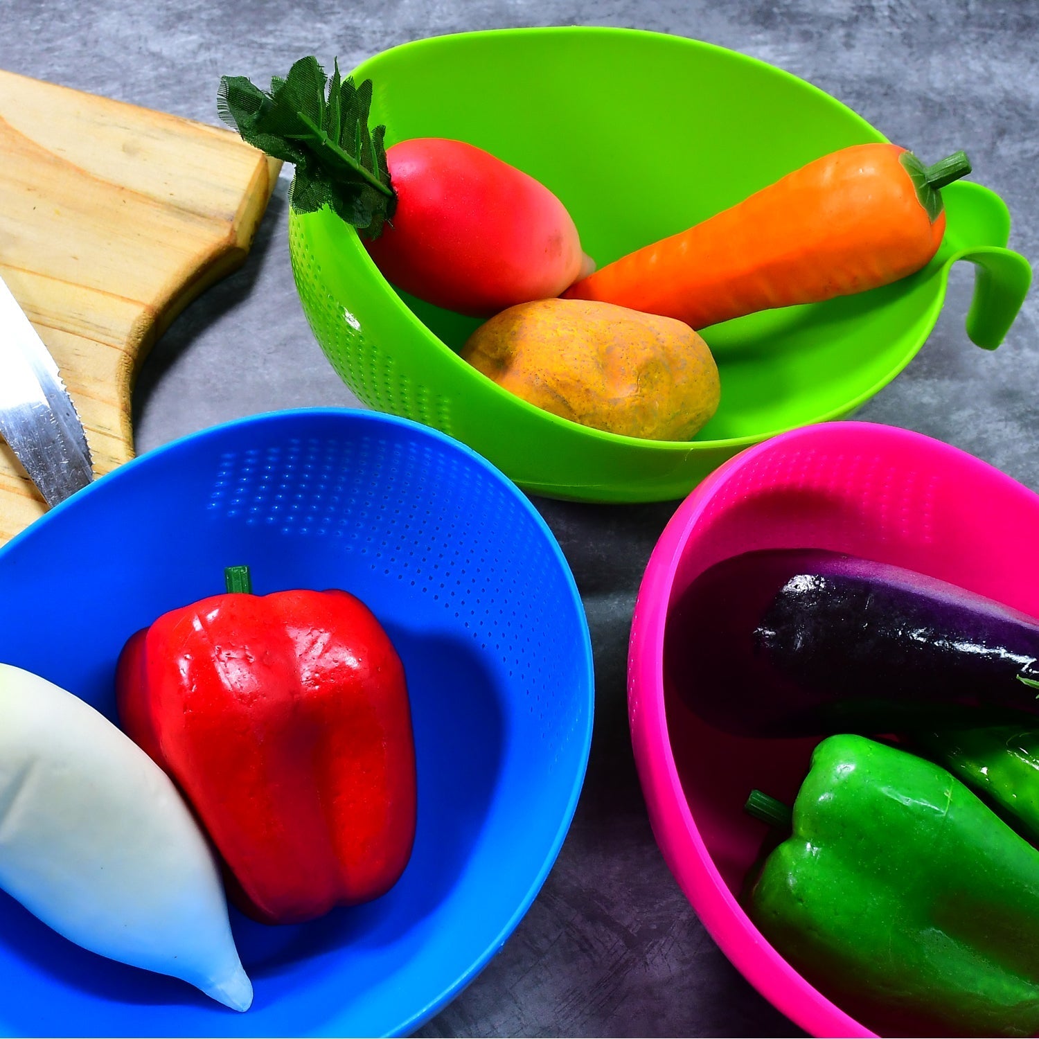 A set of plastic strainers and bowls, featuring comfortable handles for easy use.
