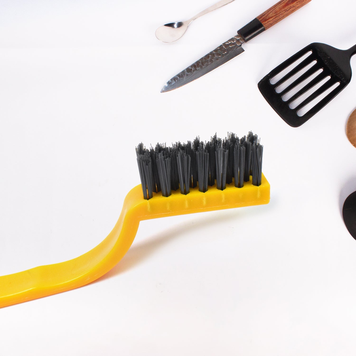Mini nylon cleaning brush tackling grime in a tight corner.