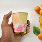 Three disposable paper cups in various vibrant colours.