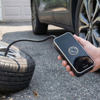 Air pump inflating car tyre outdoors with pressure nozzle