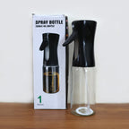 Glass oil spray bottle alongside fresh kitchen ingredients.