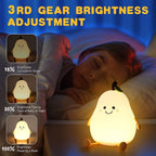 The pear-shaped night light casting a gentle glow in a dim room.