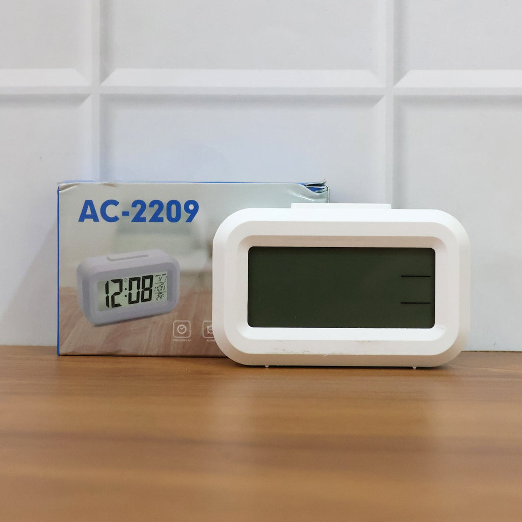 LED alarm clock on desk showing time and night light glow