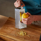Compact stainless steel food grater and slicer designed for easy storage.