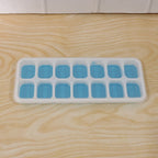 Clear plastic ice cube tray with water, ready for freezing