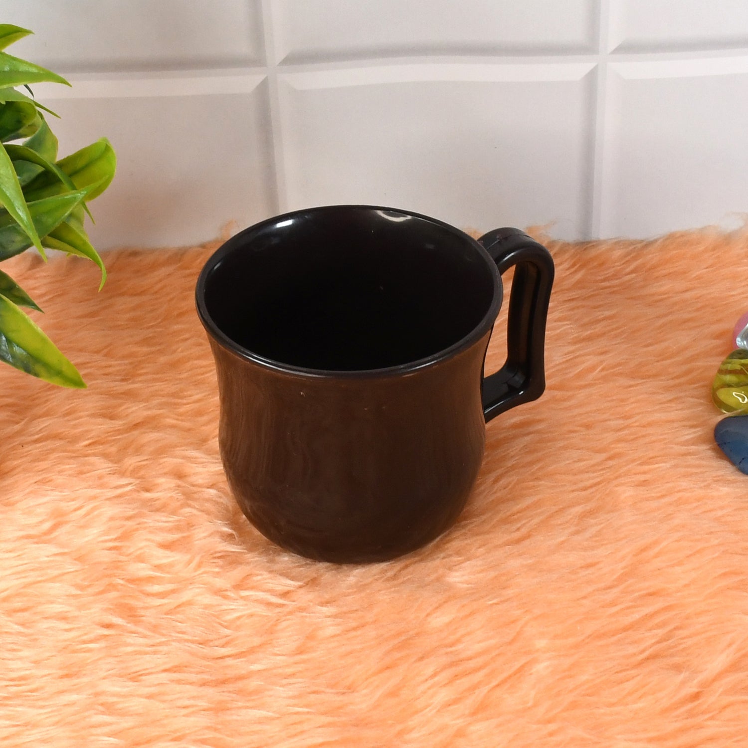 Side view of a lightweight black plastic coffee mug, emphasizing its sleek design.