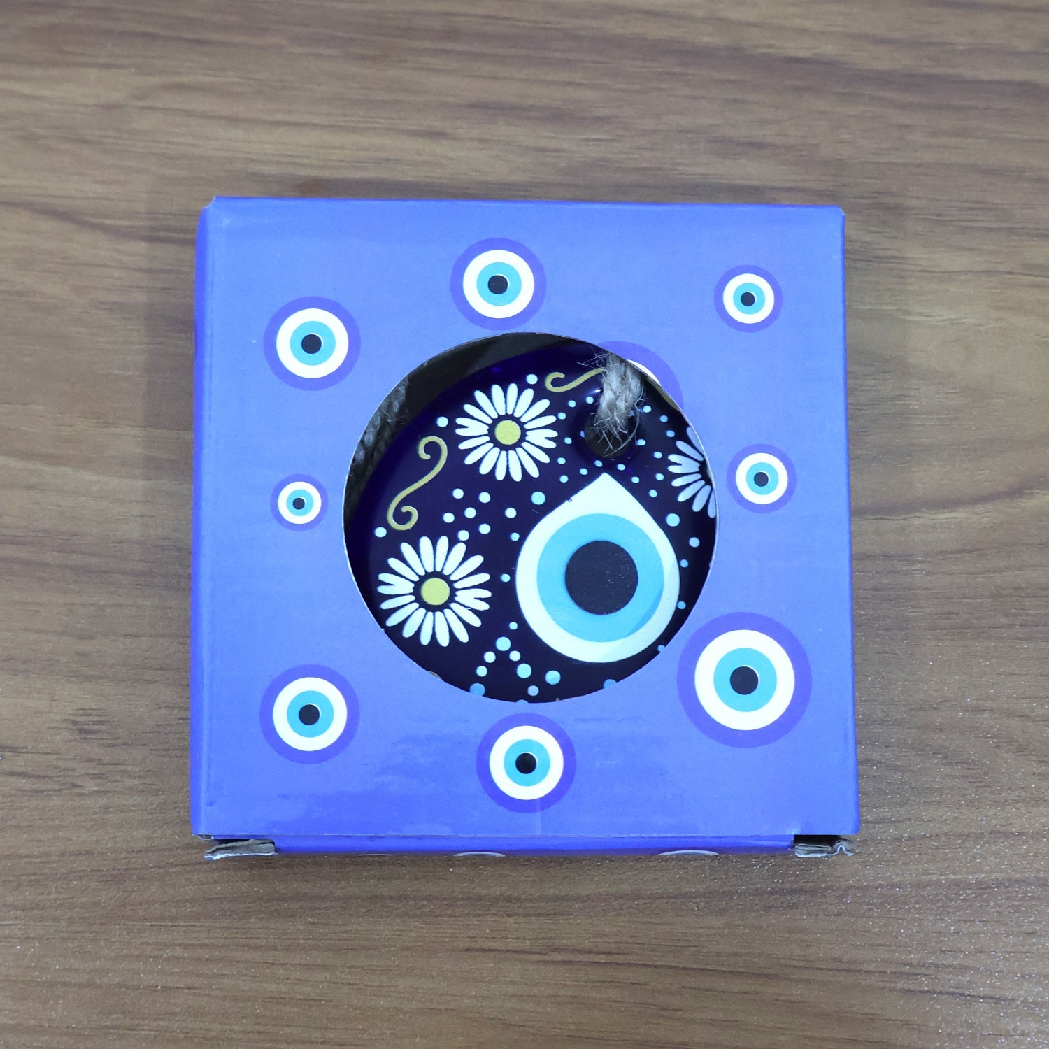 Evil Eye Wall Hanging displayed against rustic wooden background emphasizing cultural charm