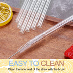 Transparent reusable glass straws arranged on a wooden surface