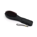 User holding the electric hair massager comb for a relaxing scalp massage.