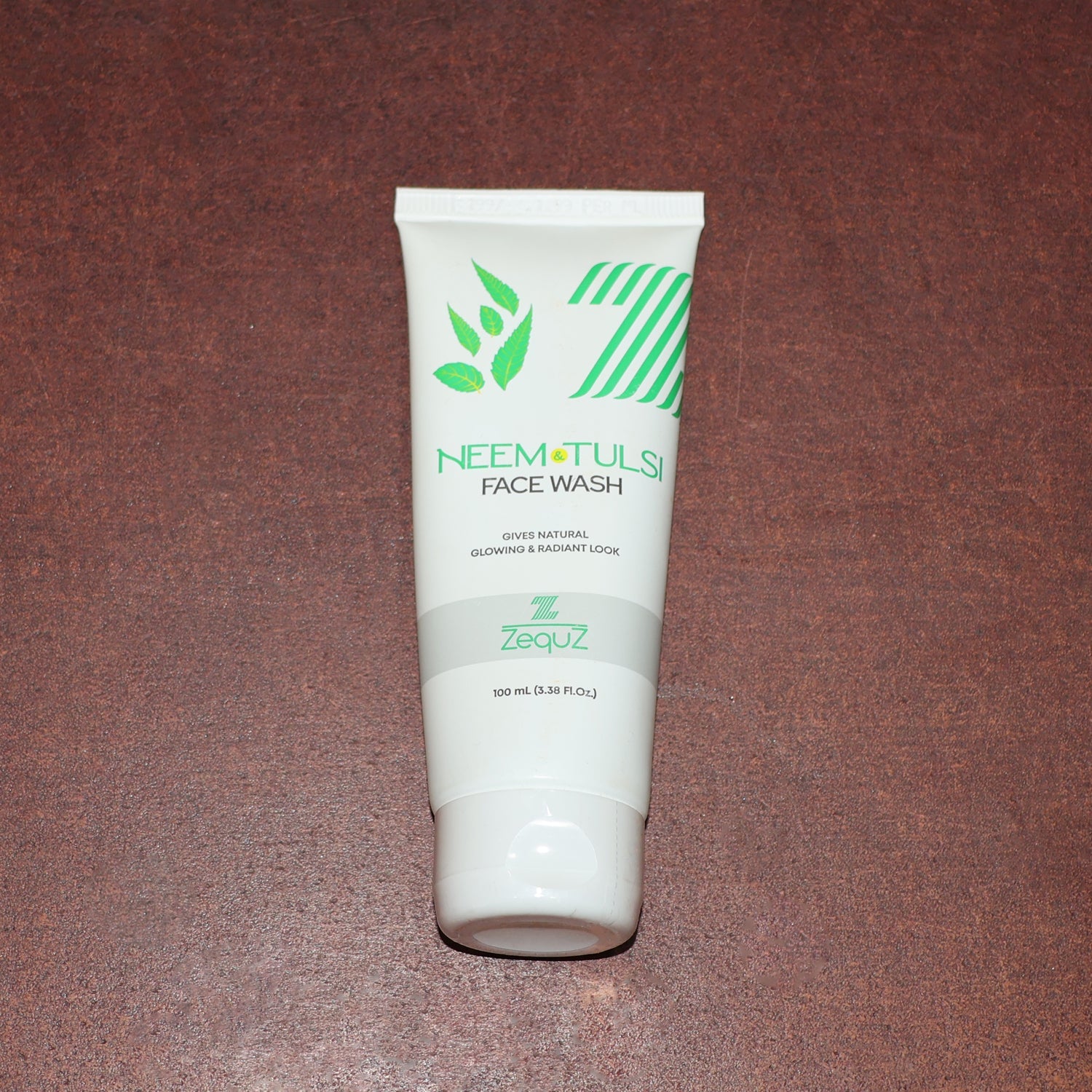 Zequz face wash tube with natural Neem and Tulsi leaves background