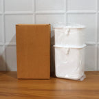 Wall mounted bathroom organizer cups holding toothbrushes and paste
