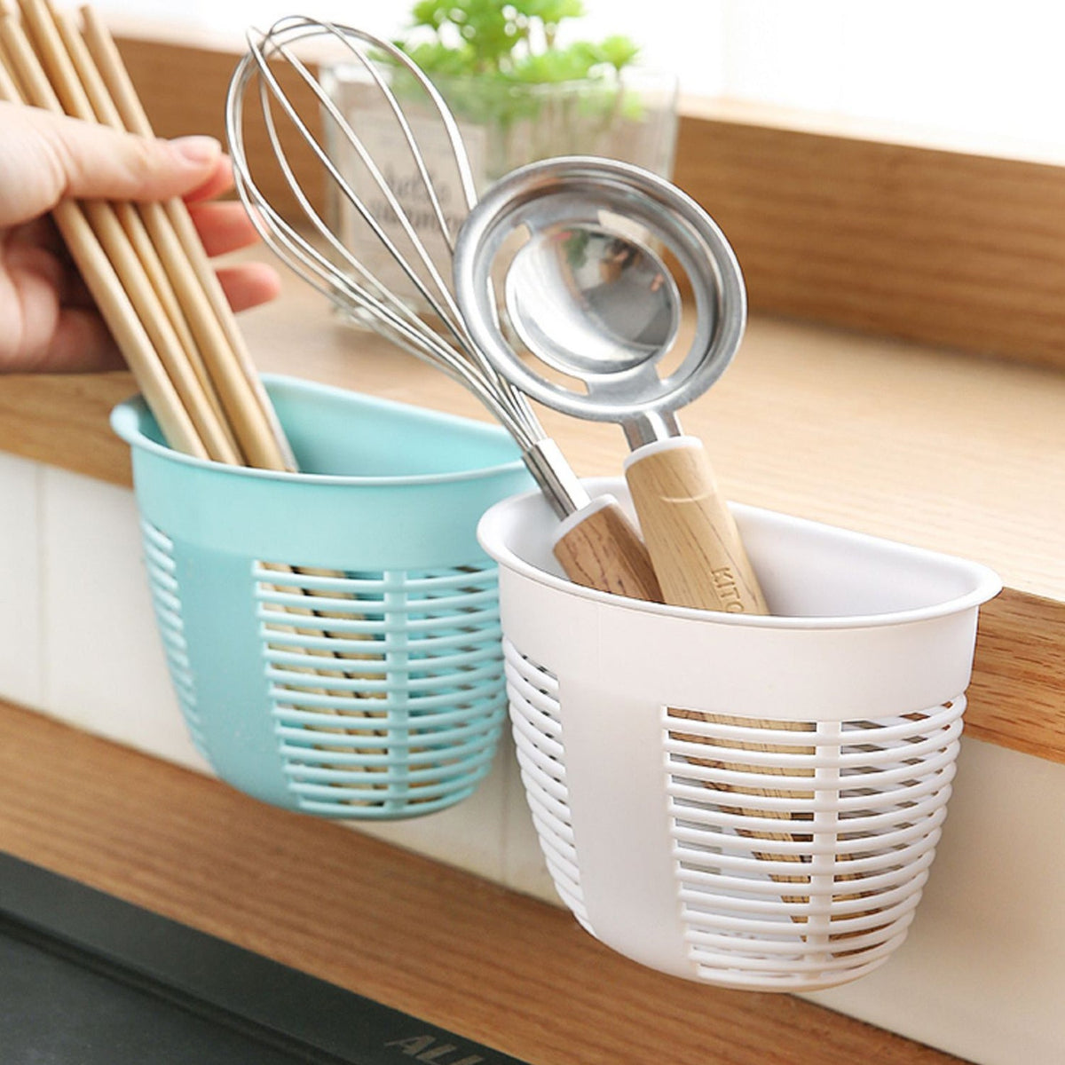 White hanging plastic storage basket mounted on a tiled wall, holding toiletries and soap.