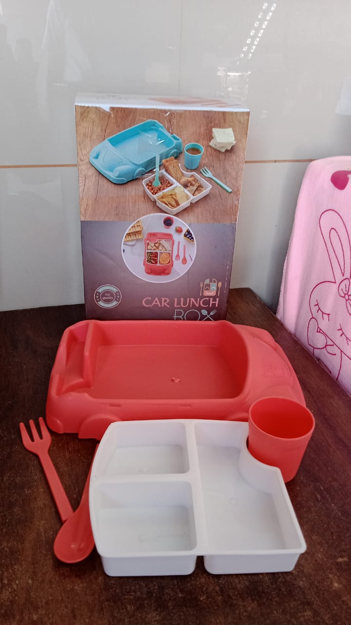 Lifestyle shot of a child interacting happily with the car-shaped dinnerware set.