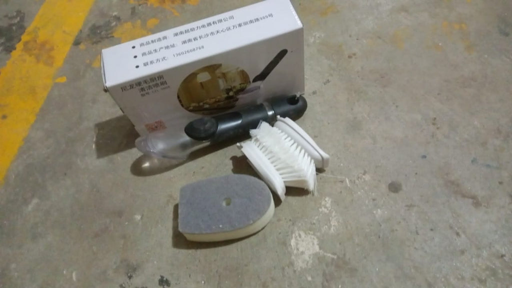 The soap dispensing dish brush in action, effectively scrubbing a dirty pot.