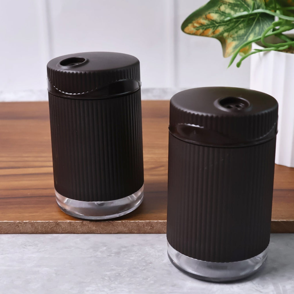 Supermom Linoo salt and pepper dispensers held in hand showing size and grip