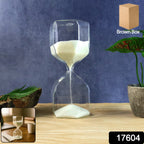 Minimalist glass hourglass sand timer placed on a wooden surface for focus and mindfulness