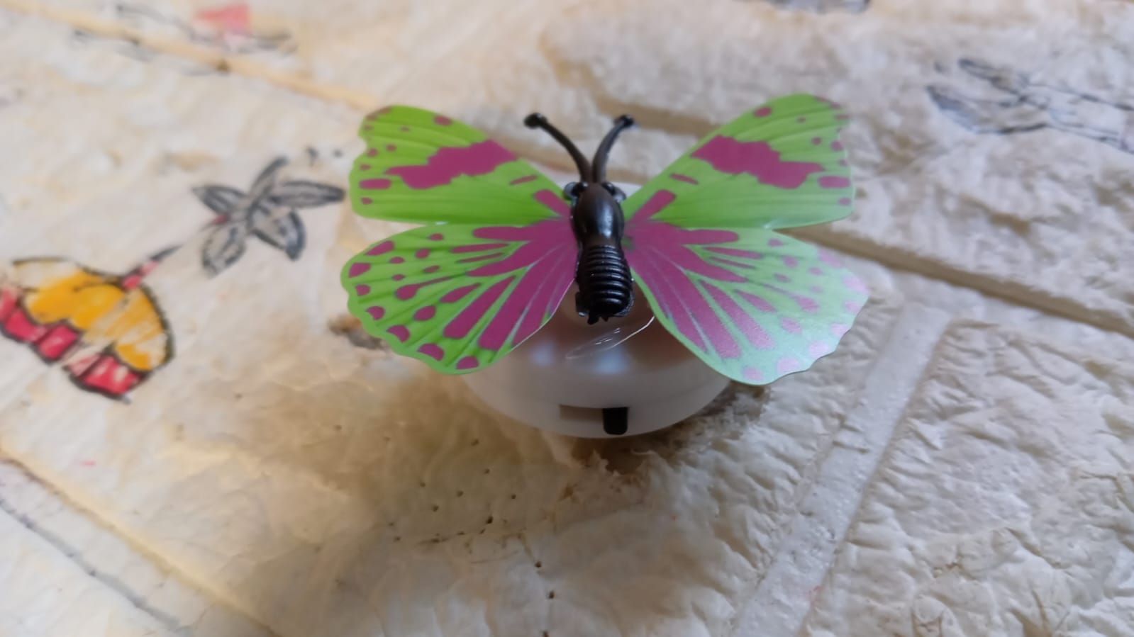 A Butterfly 3D Night Lamp glowing softly on a bedside table.