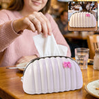 Glossy white shell shape tissue dispenser with pink bow and chrome rim