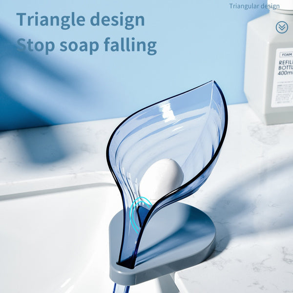 A purple leaf soap holder securely attached to a kitchen sink, holding a sponge.