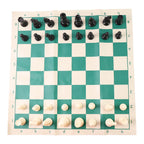 Plastic chess set pieces arranged on the roll-up green and white chess board