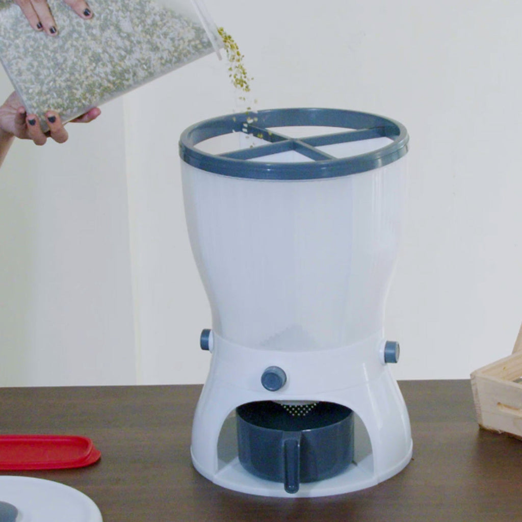 A hand pressing the button to dispense rice from the kitchen grain storage container.