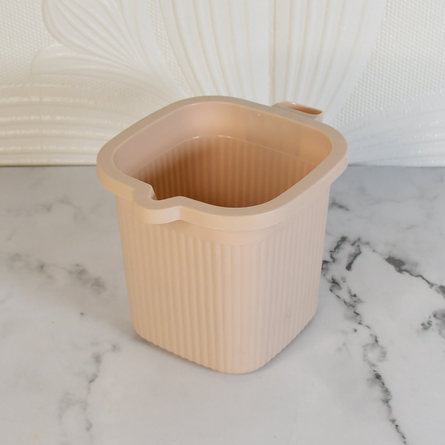 Side view of a clear Plastic Bath Mug, detailing the square base and comfortable grip.
