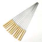 Durable stainless steel skewers laid out ready for grilling on a barbecue.