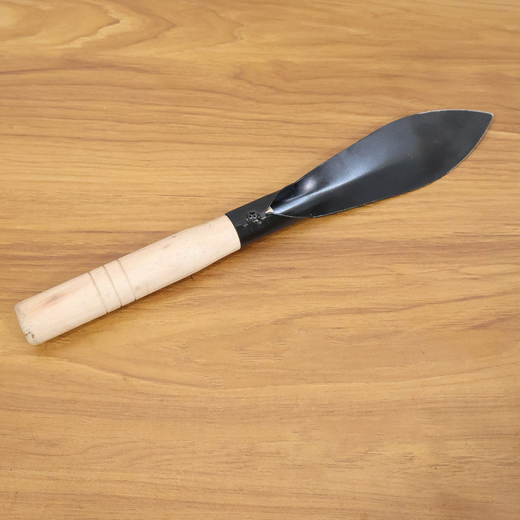 Heavy duty gardening trowel in garden setting used for planting