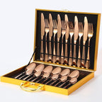 Gold cutlery set laid out on a dining table with a decorative plate.