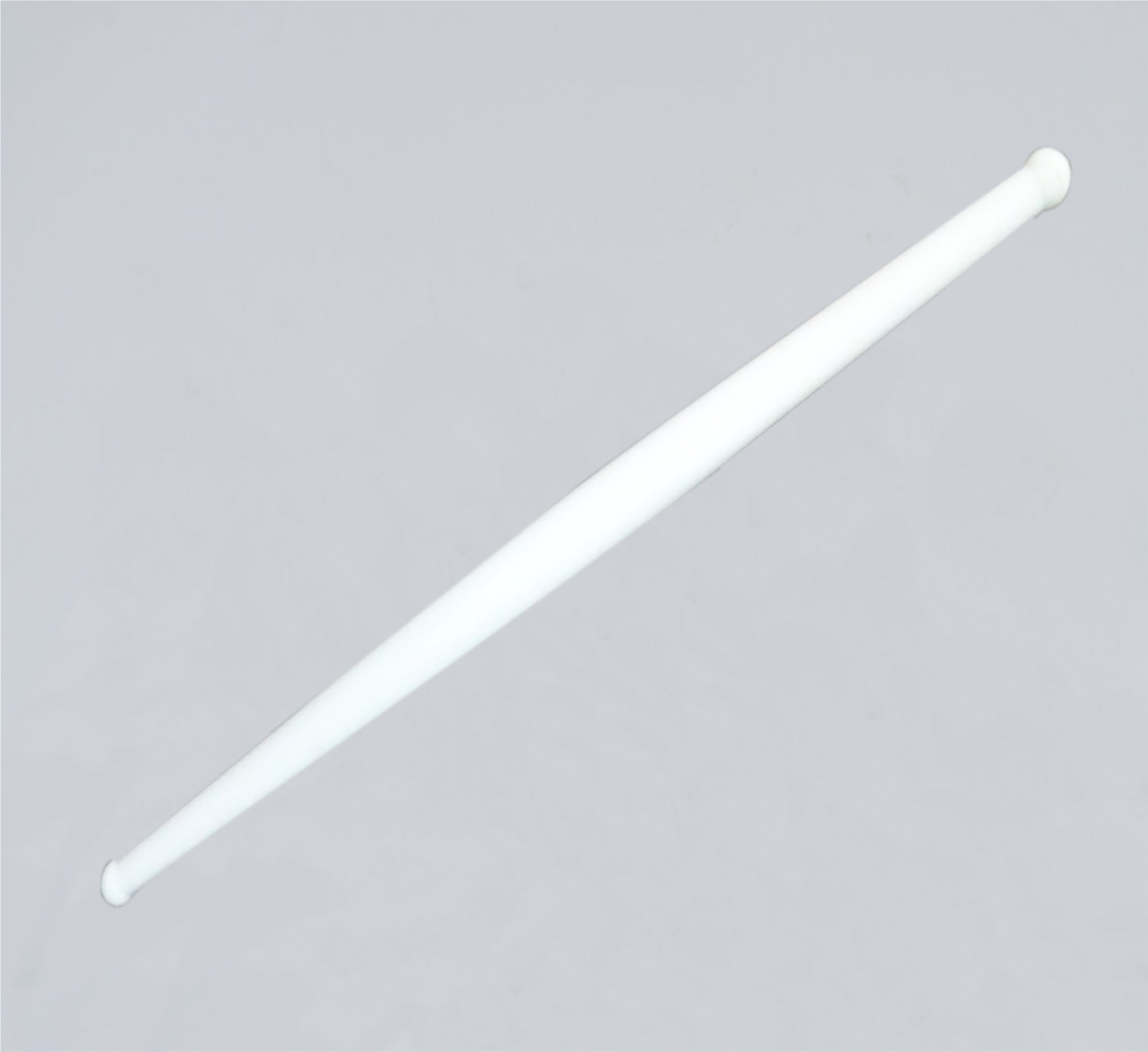 Clean white plastic rolling pin resting on a modern kitchen countertop, ready for use.