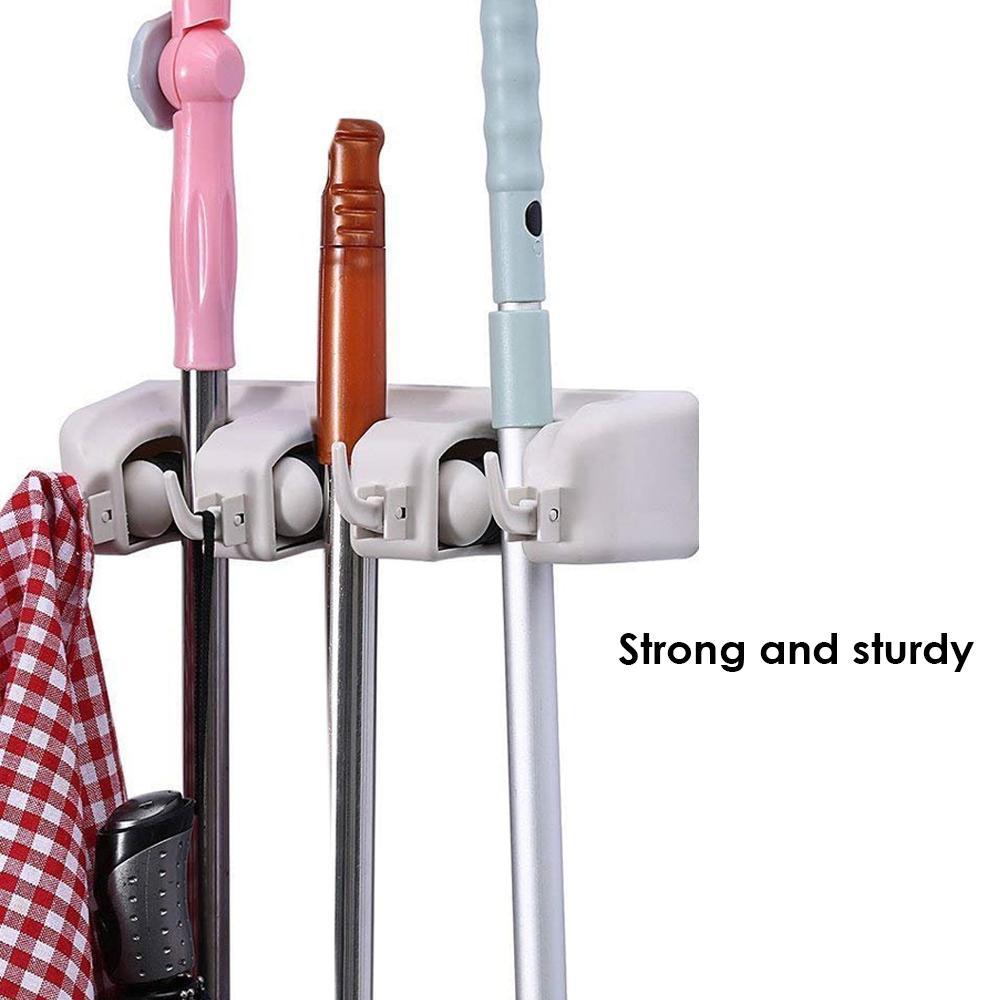GlimmerHome wall organizer with multiple brooms and mops neatly stored.