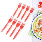 Red disposable plastic forks placed on table setting