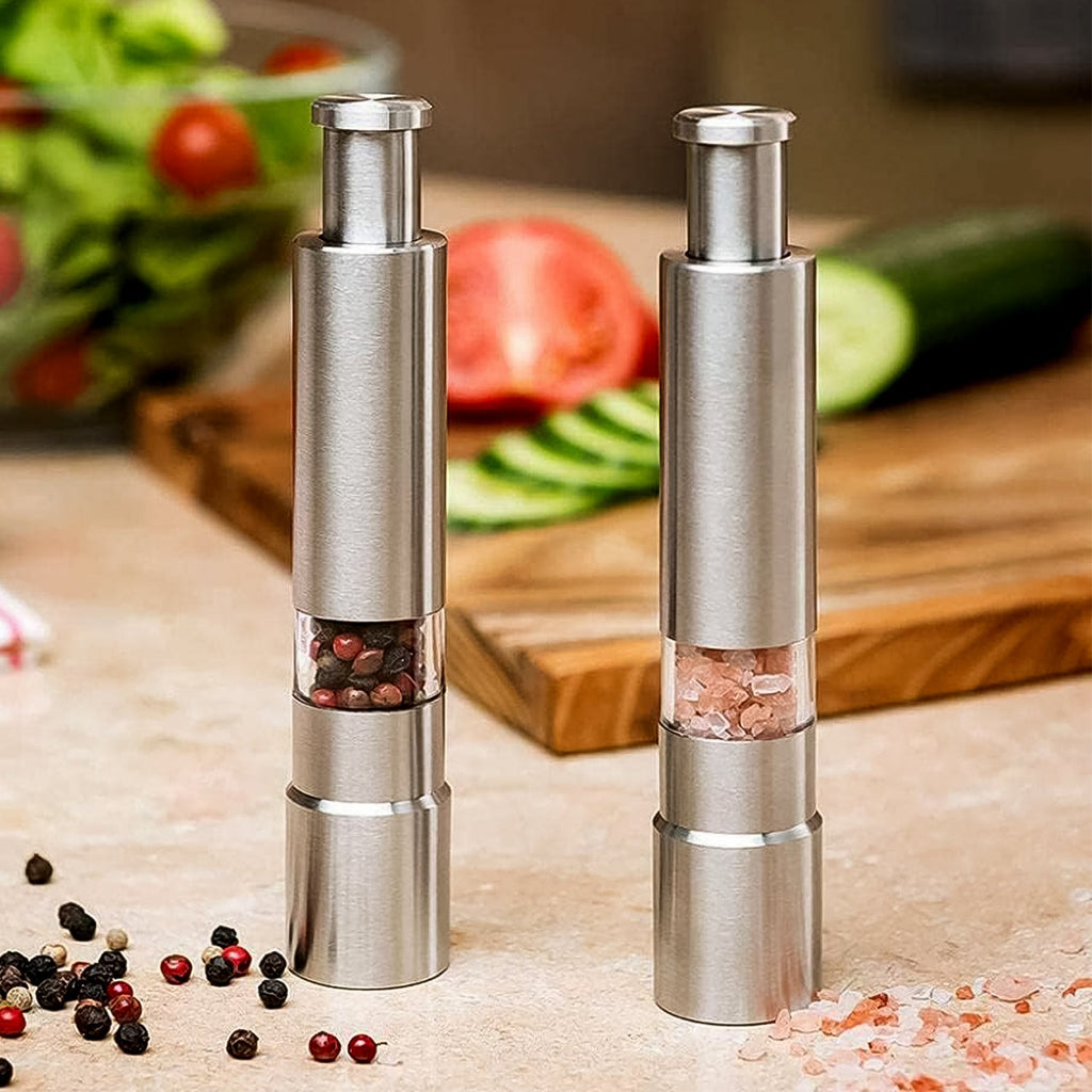 Stainless steel thumb press salt and pepper grinder on a kitchen counter.