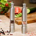 Stainless steel thumb press salt and pepper grinder on a kitchen counter.