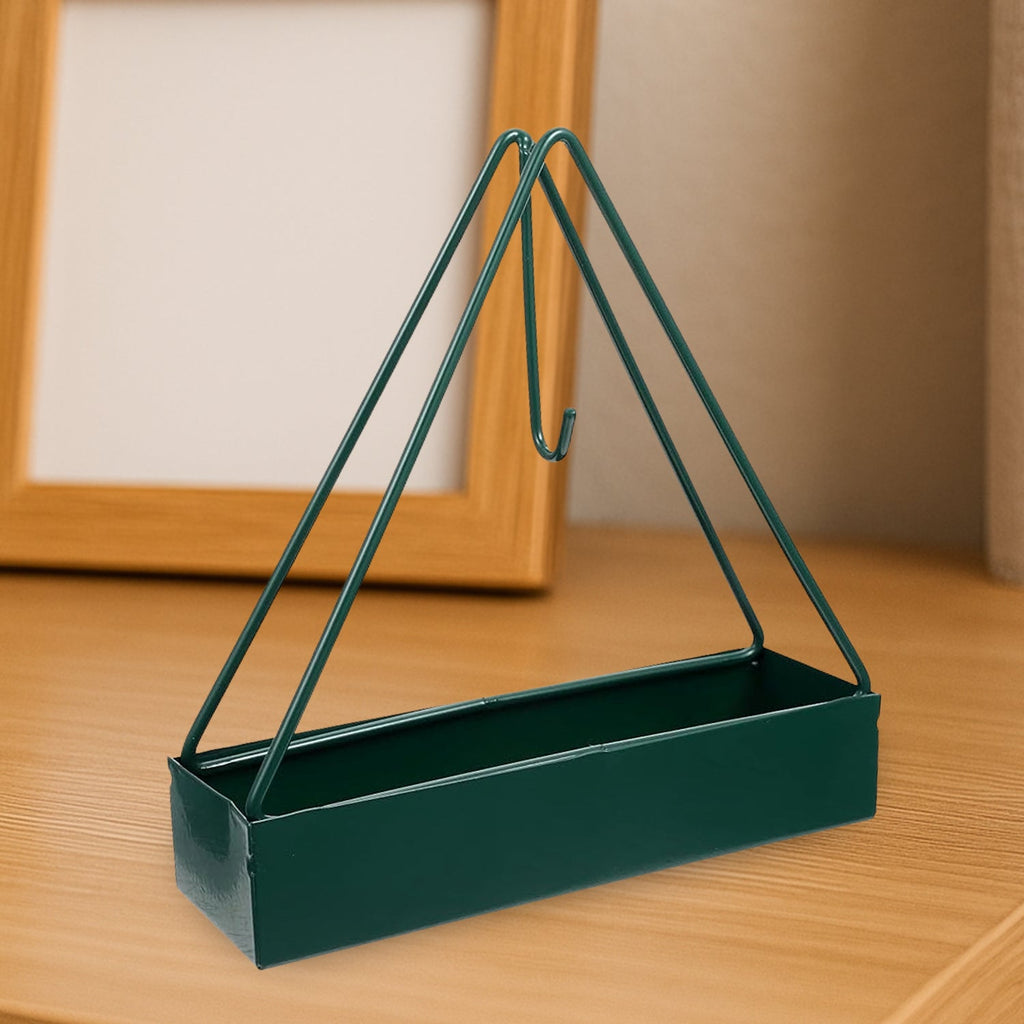Triangular iron mosquito coil holder in a lush garden setting.