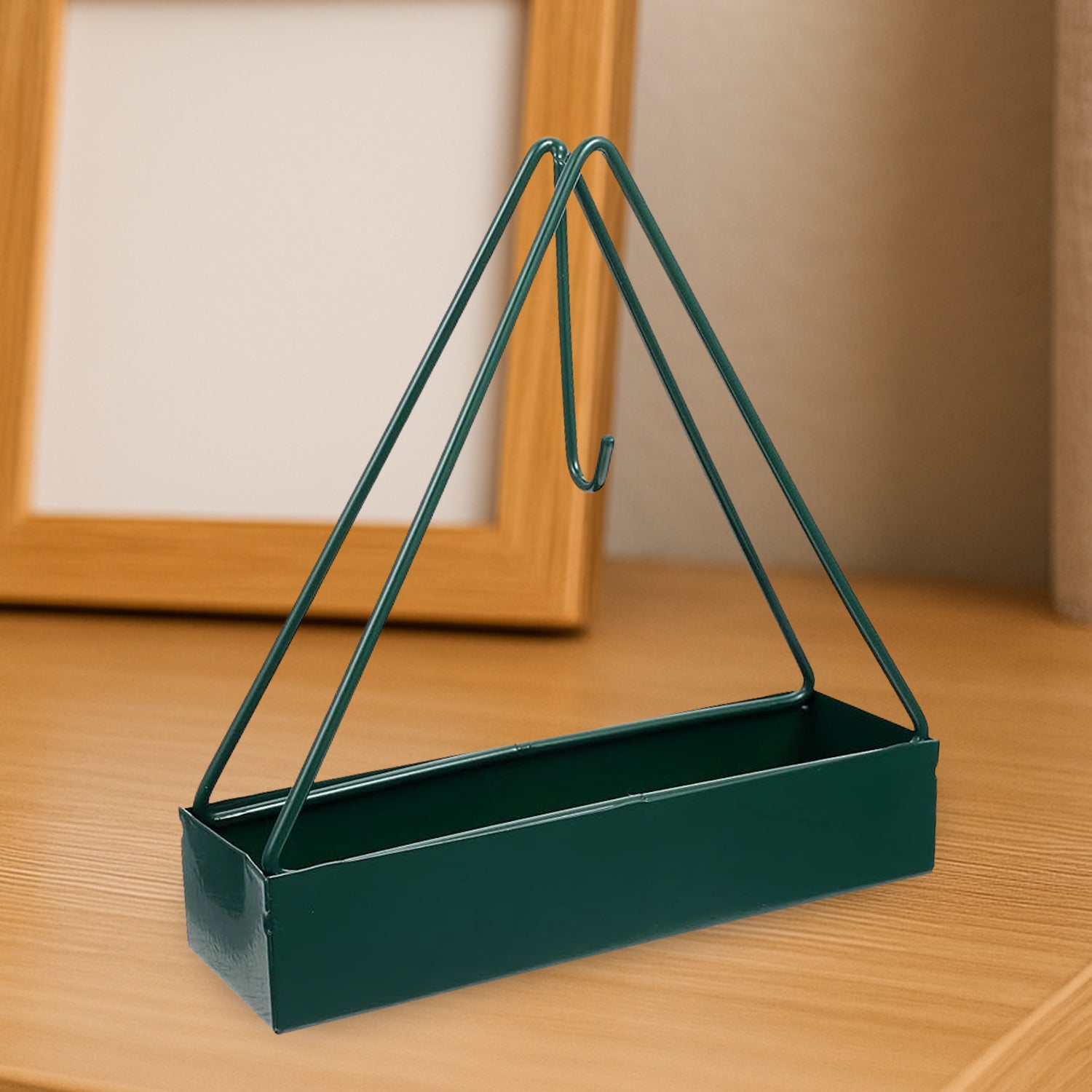 Triangular iron mosquito coil holder in a lush garden setting.